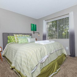 Carpeted bedroom with large window at The Oslo, located in Northglenn, CO