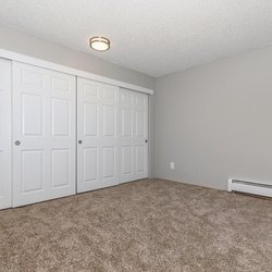 Carpeted primary bedroom with oversized closets at The Oslo, located in Northglenn, CO