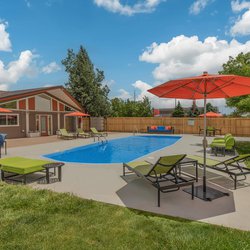 Swimming pool with lounge chairs and unbrellas at The Oslo, located in Northglenn, CO 4