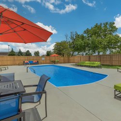 Swimming pool with lounge chairs and unbrellas at The Oslo, located in Northglenn, CO 7